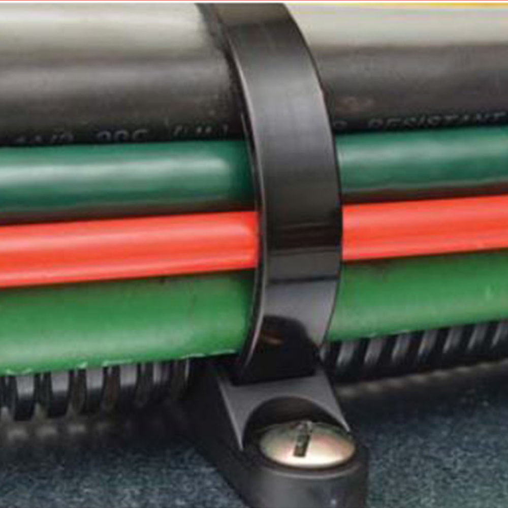 Black screw mount cable tie securing organized electrical cables in industrial cable management system with nylon zip tie and screw fixed mounting base