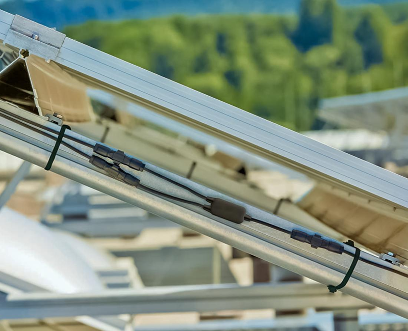 Heavy duty UV-resistant black zip ties organizing solar panel wiring on a mounting frame, ideal for outdoor electrical cable management and renewable energy installations.