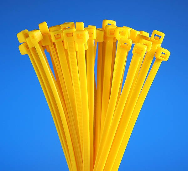 Close-up of yellow nylon zip ties featuring self-locking heads, designed for cable management, wire bundling, and secure fastening applications.