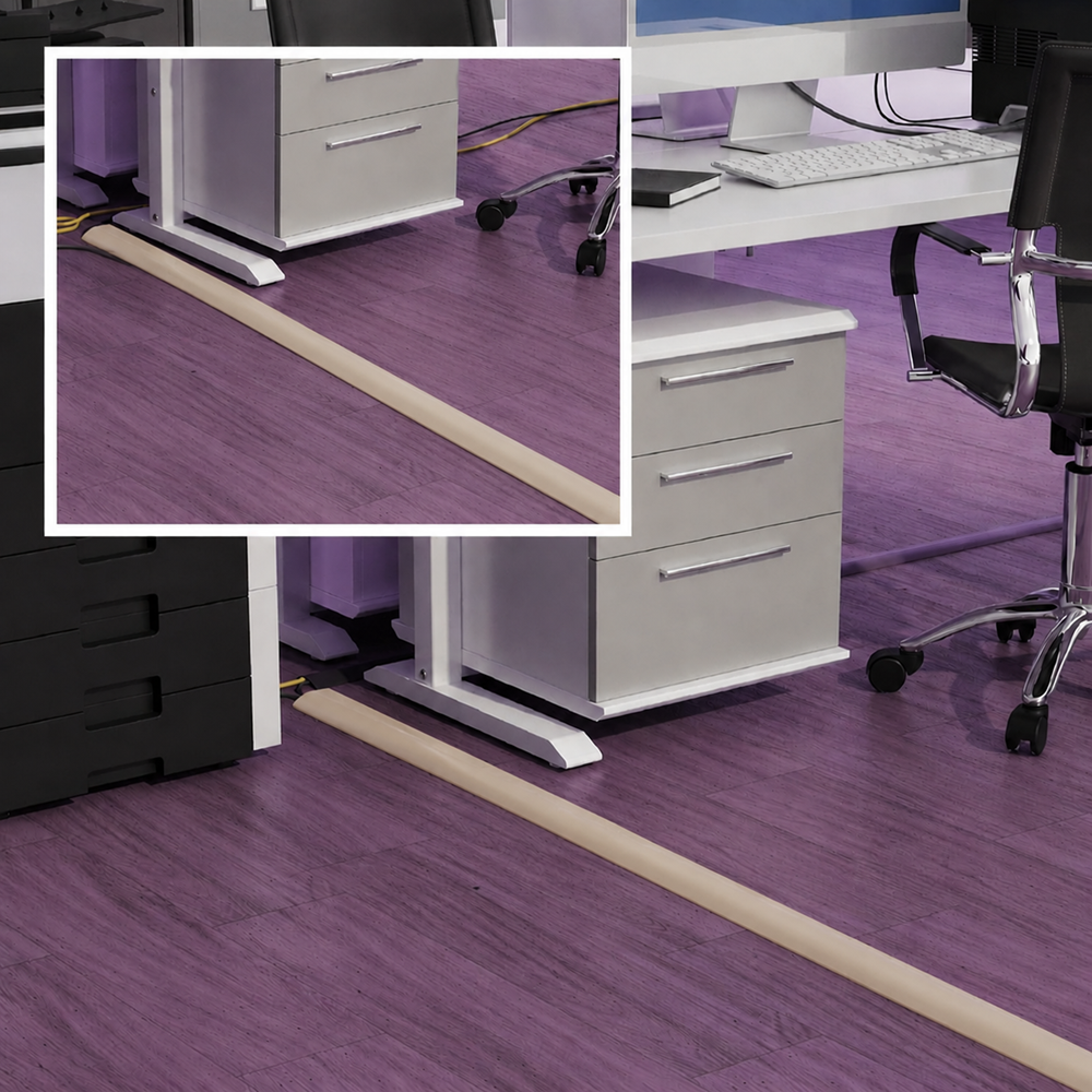 Beige cord cover cable protector installed on office floor with desks and computers, floor cable management solution for hiding and protecting wires in a modern workspace