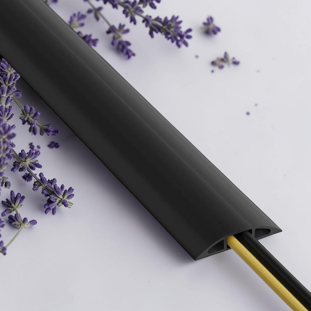 Black cord cover cable protector with exposed wires on a clean lavender flower background, flexible floor cable management solution for organizing and protecting cables