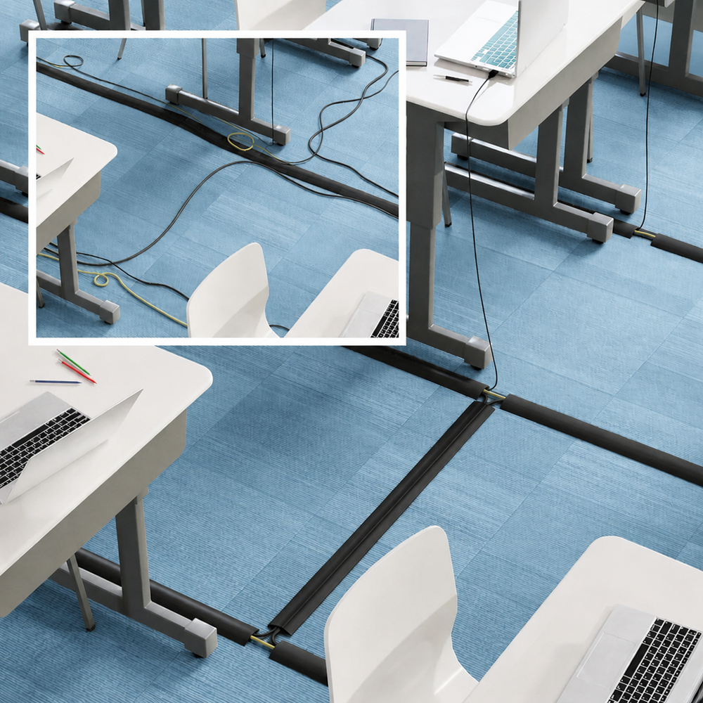 Black cord cover cable protector installed across a blue office floor with desks, chairs, and computer cables, modern workplace cable management solution for organizing and protecting electrical wires