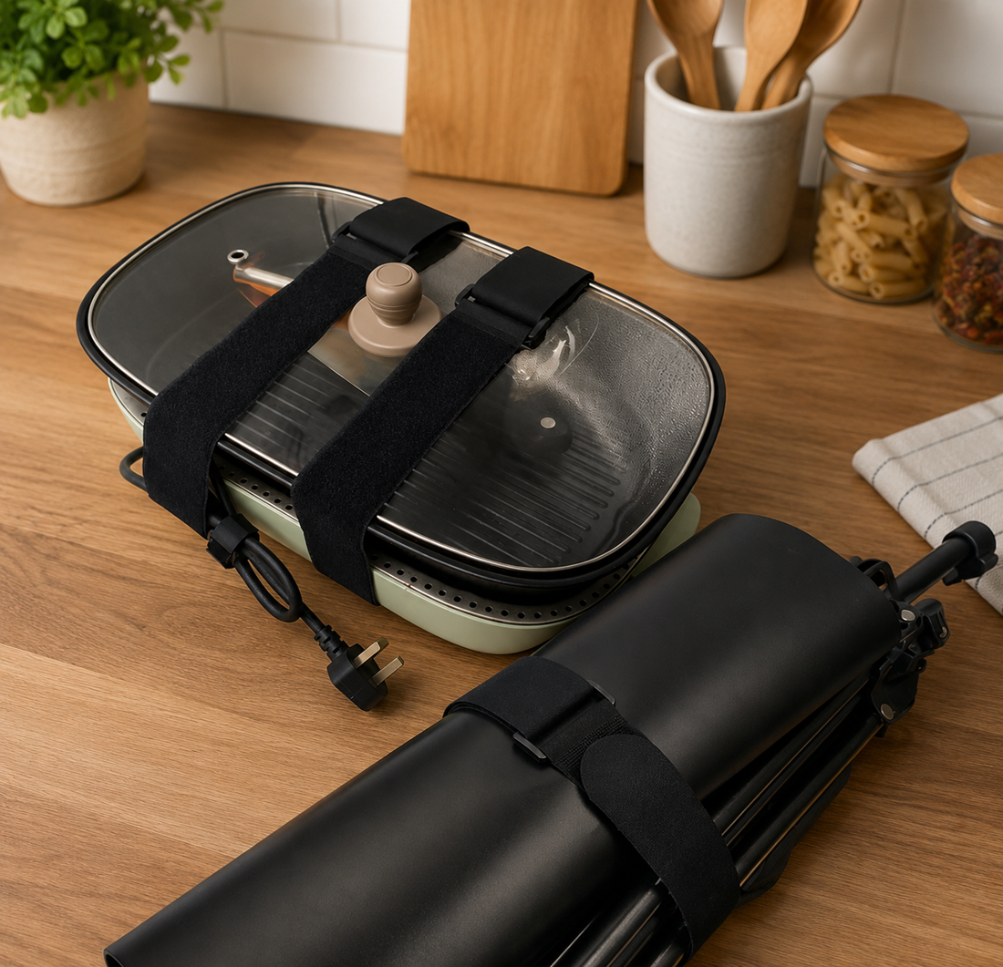 Reusable hook and loop straps securing an electric grill and folded tripod on a kitchen countertop with a natural kitchen background.