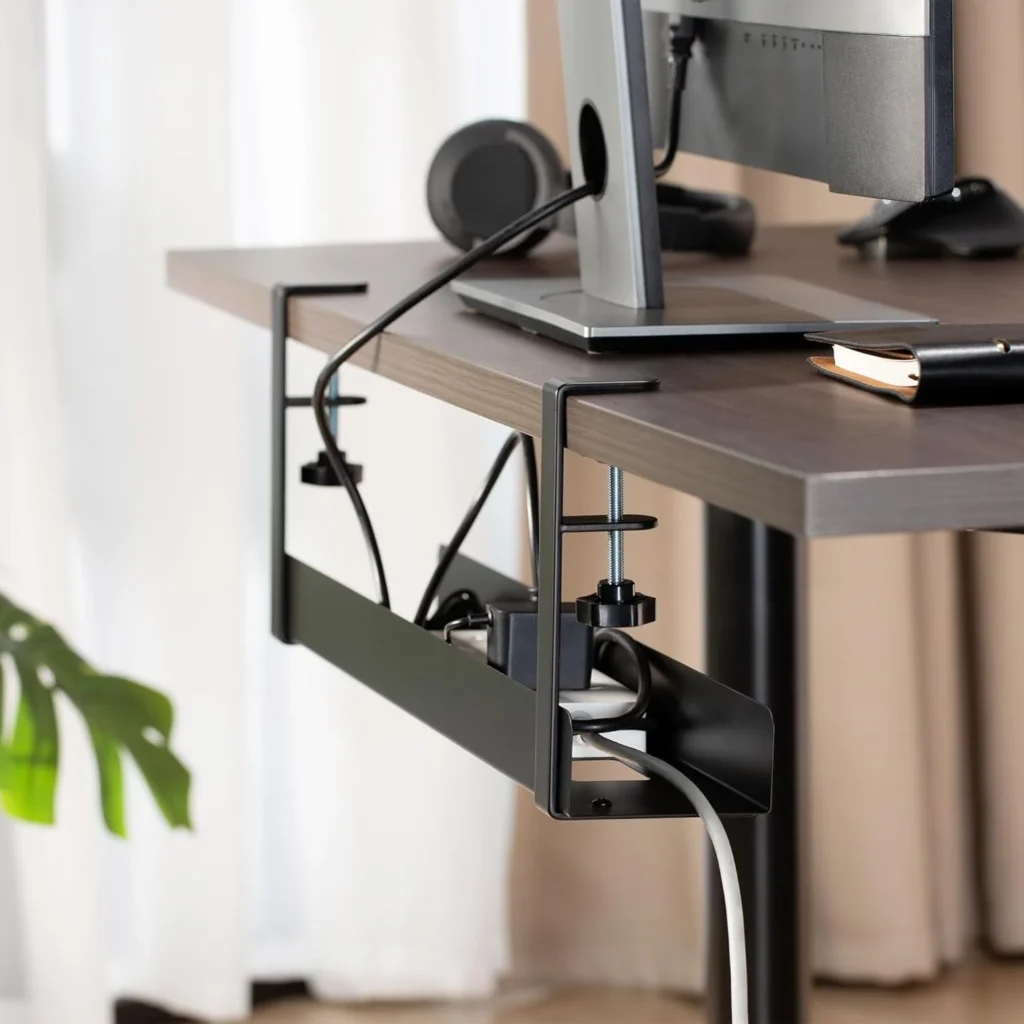 Metal mesh under-desk cable management tray with clamp mount securing cords near a desk