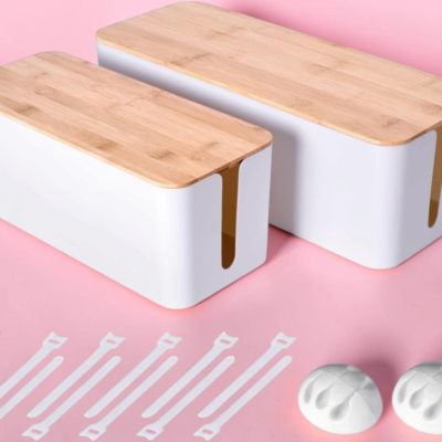 Two white cable management boxes with bamboo lids, five reusable cable ties, and two cable clips on a pink background.